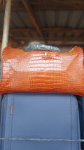 orange crocodile embossed duffle bag.