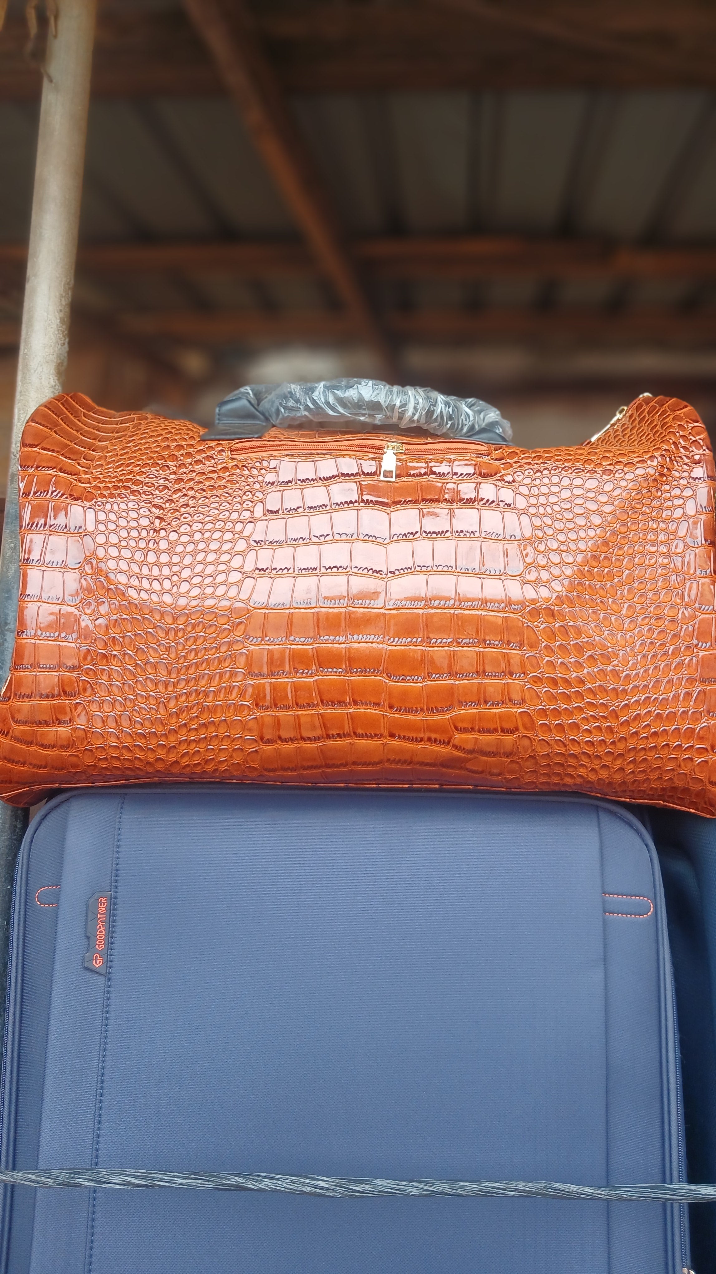 orange crocodile embossed duffle bag.