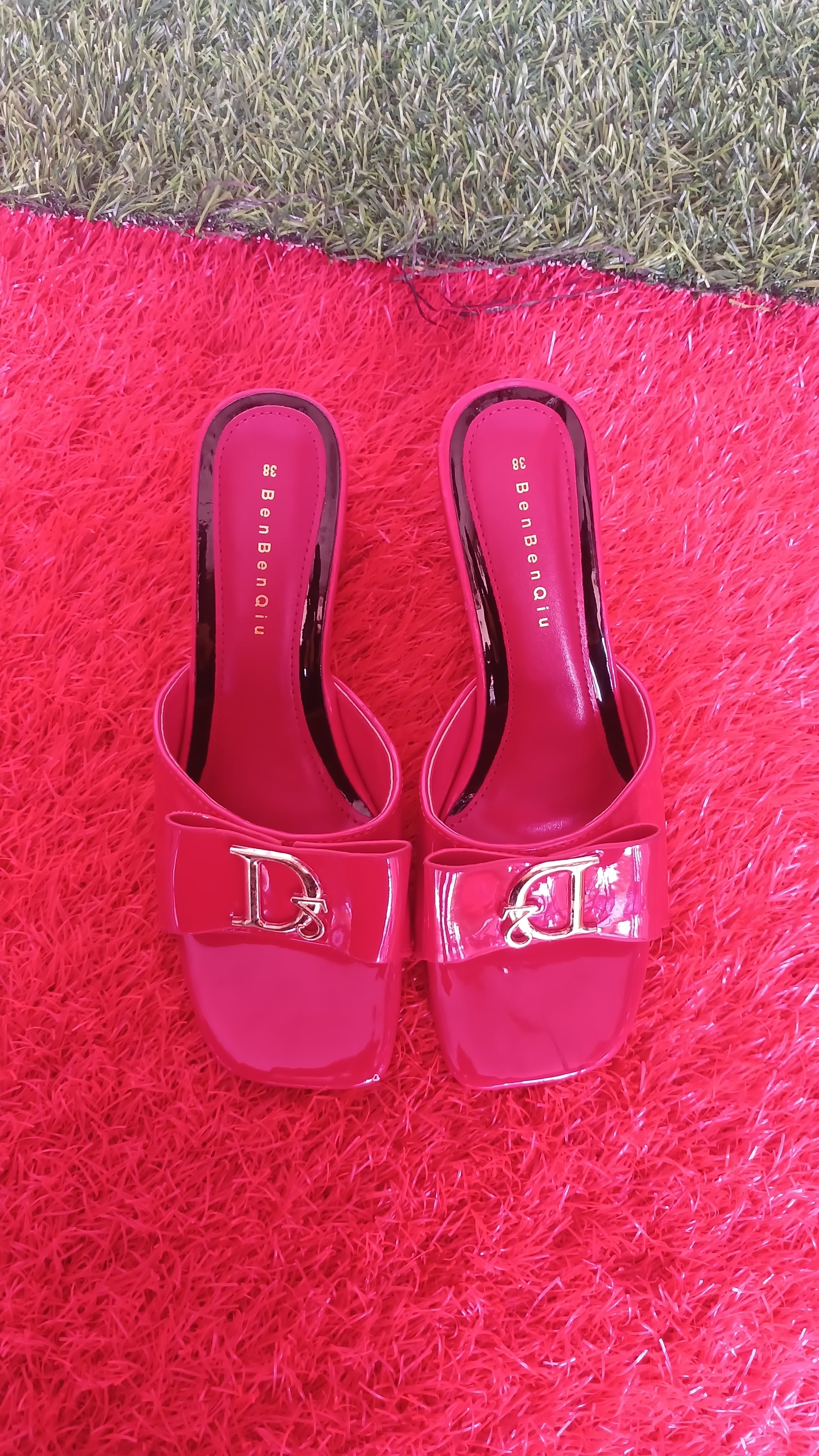 BenBenQiu pink slip-on heels prominent metallic letter emblem.