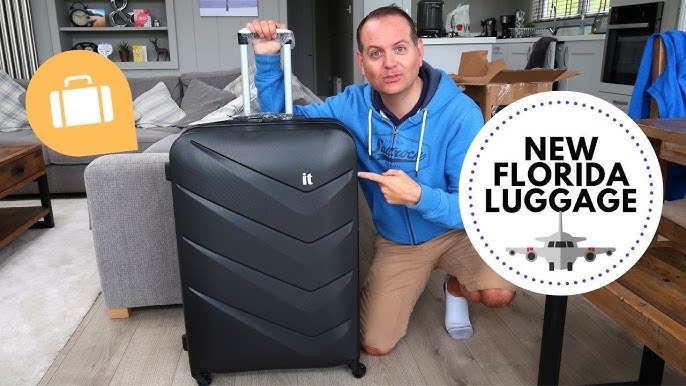 a black IT Luggage Chevron hard-shell suitcase featuring a textured finish and multi-directional wheels.