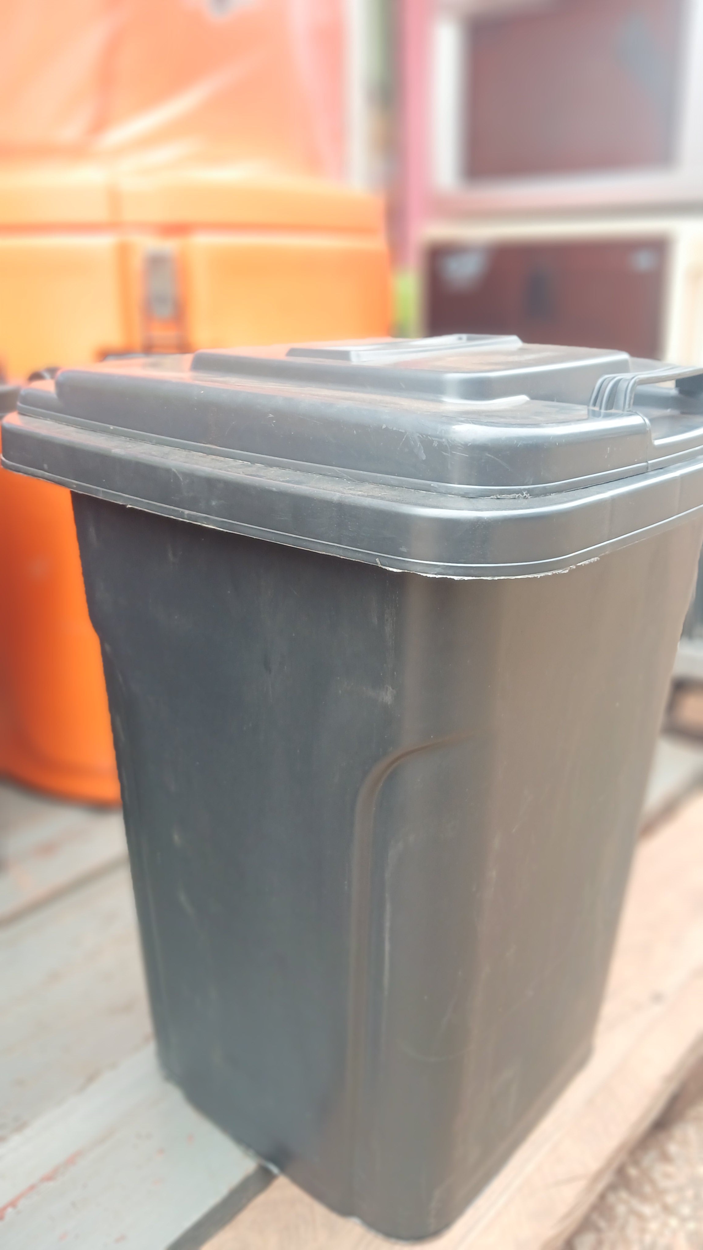 black plastic garbage can, for waste disposal.