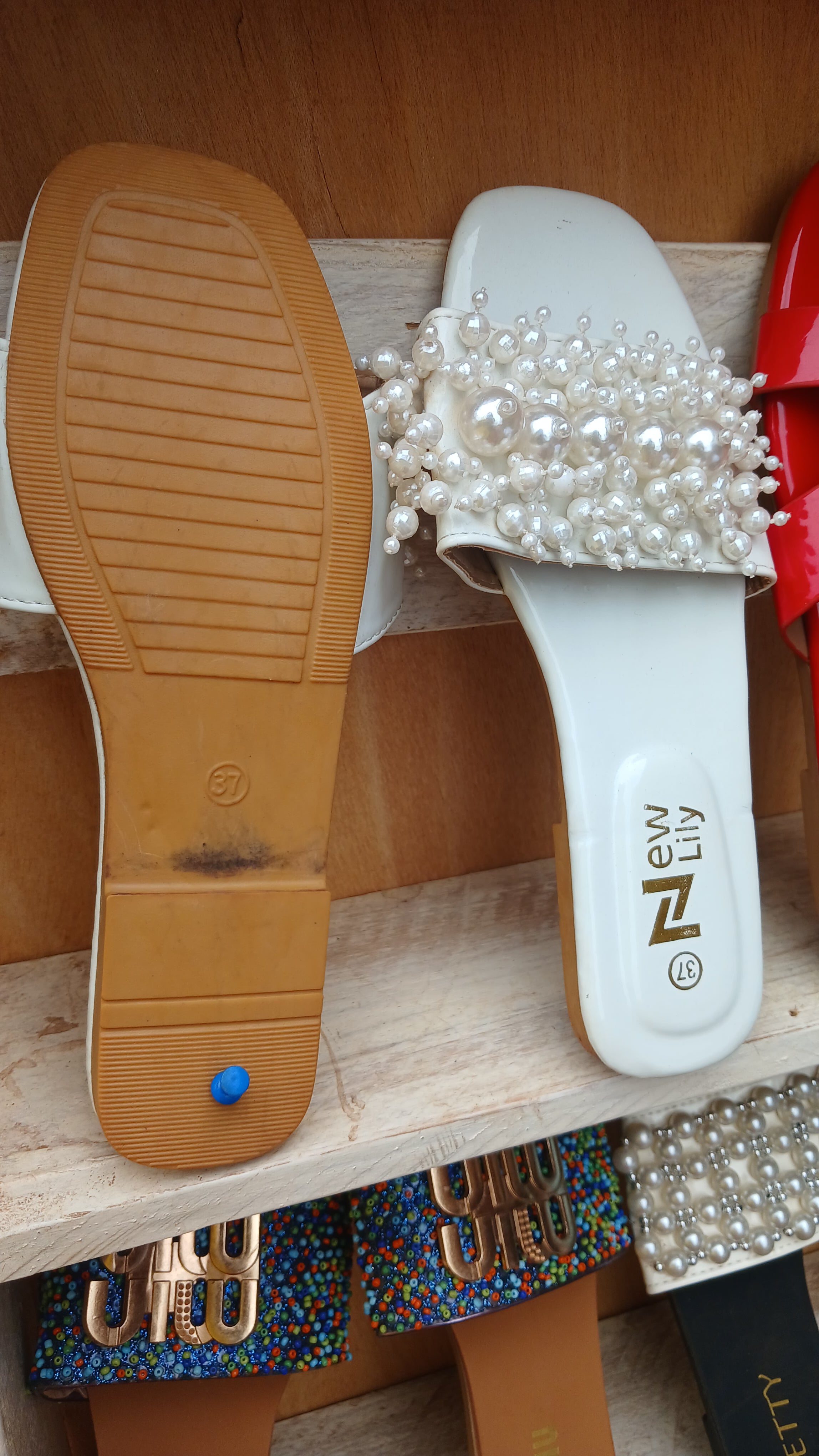 white ladies' sandal with a decorative pearl-embellished strap.