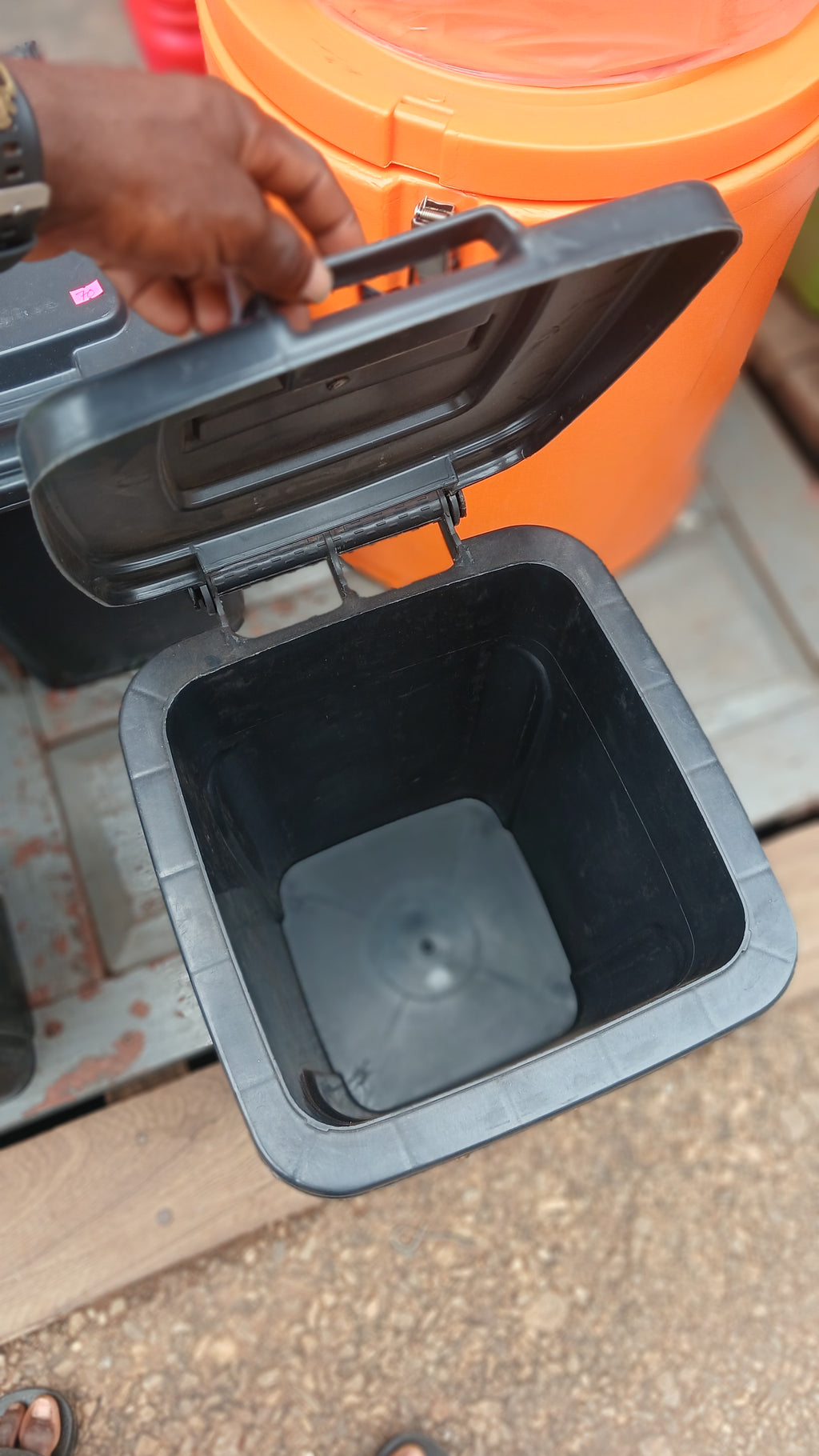 black plastic garbage can, for waste disposal.